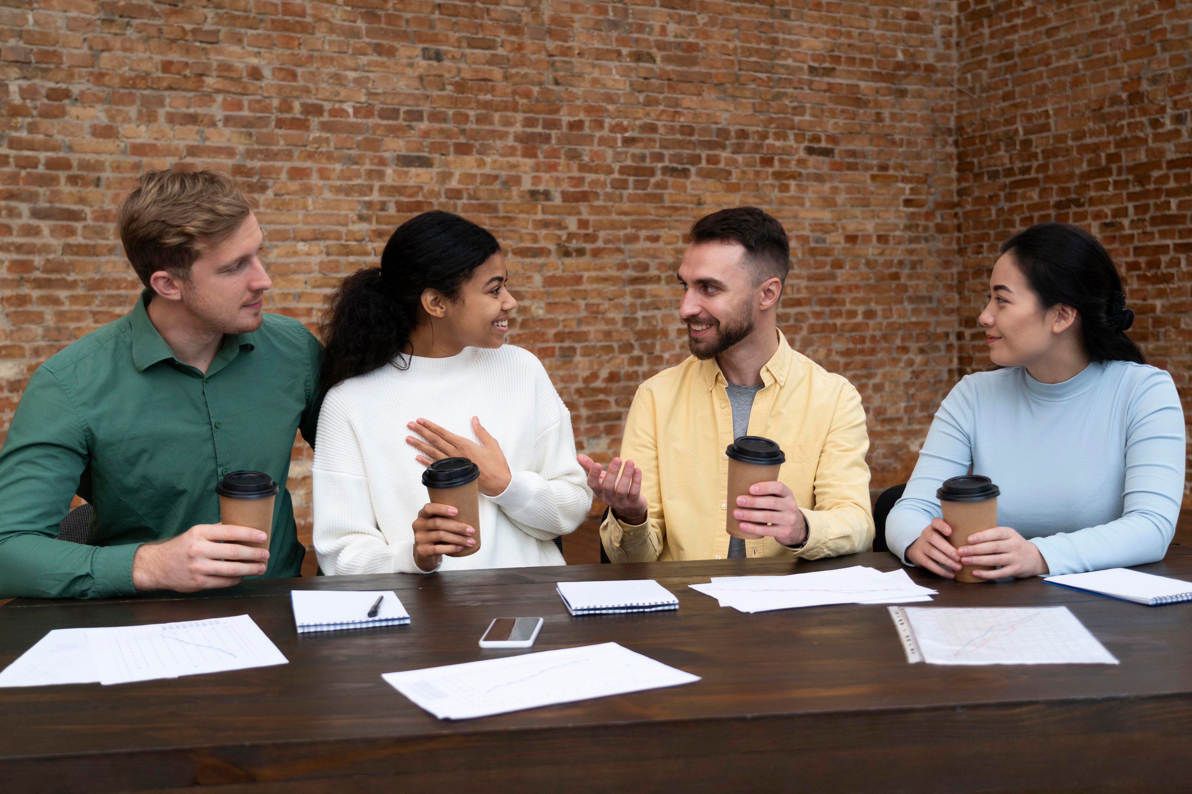 group of people talking while working on the computer